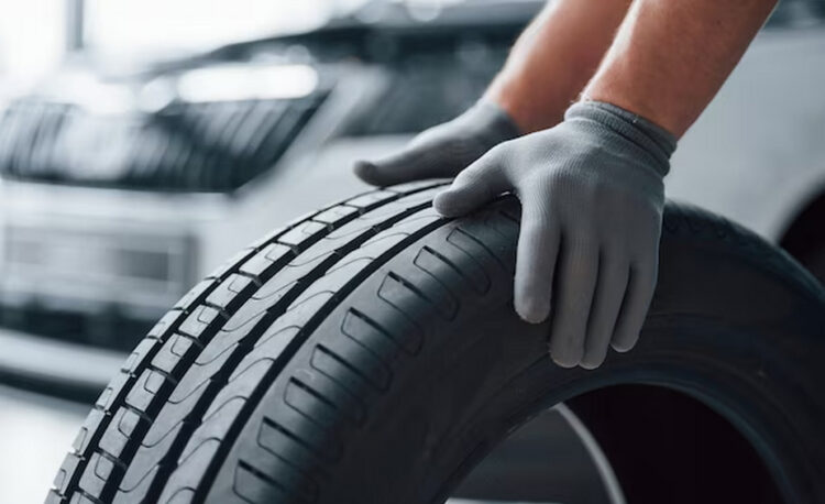 mechanic holding a tire